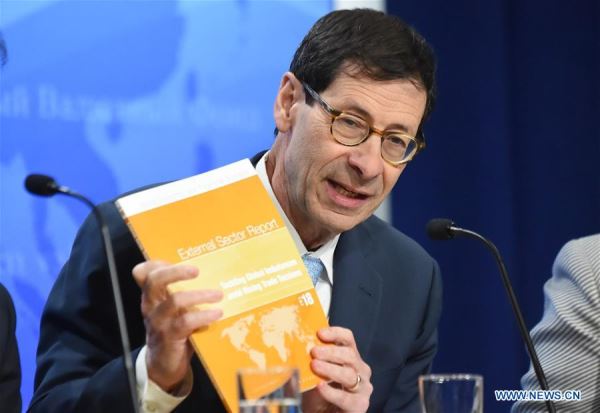 Maurice Obstfeld, Economic Counsellor and Director of Research at the International Monetary Fund (IMF), shows the newly-released 2018 External Sector Report at a press conference in Washington D.C., the United States, on July 24, 2018. [Photo: Xinhua]