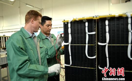 车间生产线上技术人员正在测试组装好的电容模块。　刘忠俊 摄